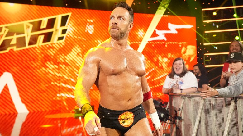 LA Knight makes his entrance as fans cheer, with his signature “Yeah!” branding displayed behind him on the WWE stage