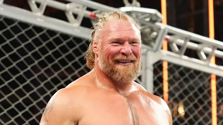 Professional wrestler Brock Lesnar smiles broadly inside a steel cage during a WWE event.