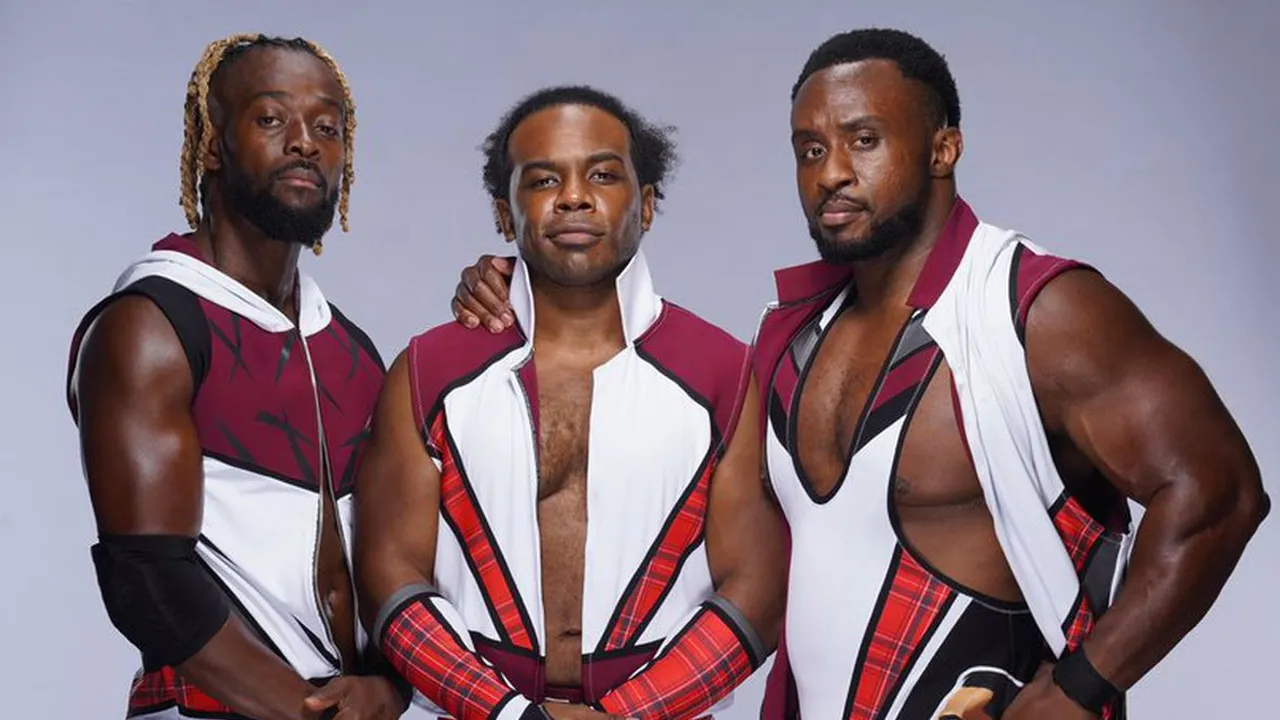 A promotional photograph of the three members of The New Day wrestling stable: Kofi Kingston, Xavier Woods, and Big E, posing in matching maroon and white vests.