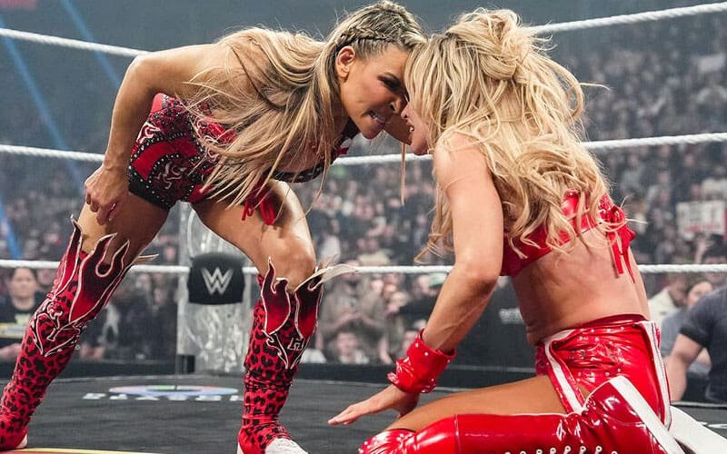 Natalya stares down a kneeling Maxxine Dupri in a WWE wrestling ring.