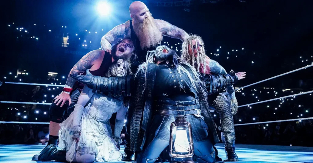 The wyatt sicks faction poses in the ring under dim lighting, featuring eerie costumes and a lantern at the center. - tjr wrestling