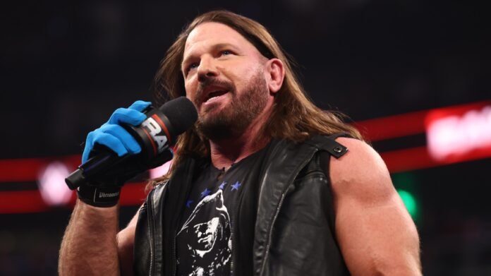 AJ Styles speaks during a WWE live event while holding a microphone inside the ring.