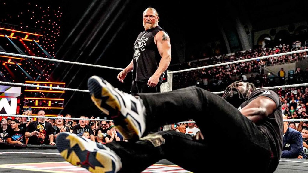 Brock lesnar stands over a fallen oba femi inside the wwe ring after launching a surprise attack during wwe raw.