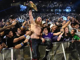 Sami Zayn celebrates with the WWE Championship while standing among fans after winning the title at WWE Night of Champions 2026.