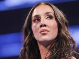 Why Chelsea Green Fought Through A Painful Facial Injury Now Close-up shot of WWE Superstar Chelsea Green with noticeable bruising under her right eye looking upward against a blue-lit stage background.