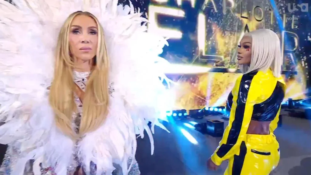 Charlotte flair wearing a elaborate white feathered robe stands in the foreground while jade cargill in a yellow and black jumpsuit looks on from behind. - tjr wrestling