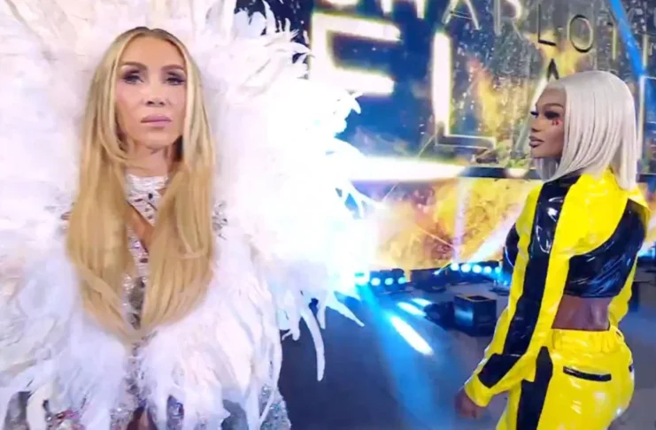Charlotte Flair wearing a elaborate white feathered robe stands in the foreground while Jade Cargill in a yellow and black jumpsuit looks on from behind.